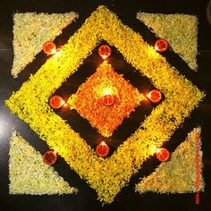 an arrangement of flowers and candles in the shape of a square on top of grass