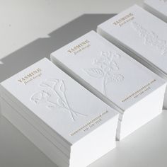 four white business cards stacked on top of each other