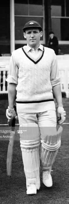 black and white photograph of a man holding a cricket bat