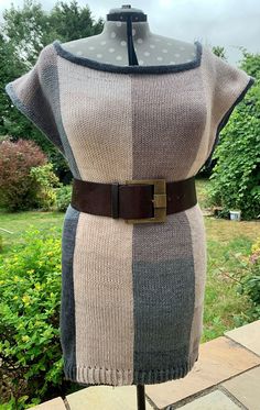 a dress on a mannequin with a brown belt