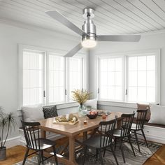 a dining room table with four chairs and a ceiling fan in the middle of it