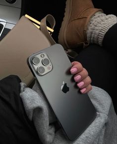 a woman holding an iphone 11 in her hand with the camera on it's back