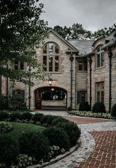 a large brick house with lots of windows and stone walkway leading to the front door