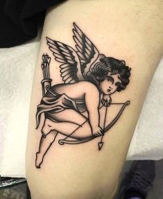 an angel tattoo on the leg of a person with a bow and arrow in her hand