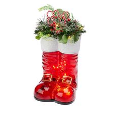 a pair of red boots with candy canes and greenery in them on a white background