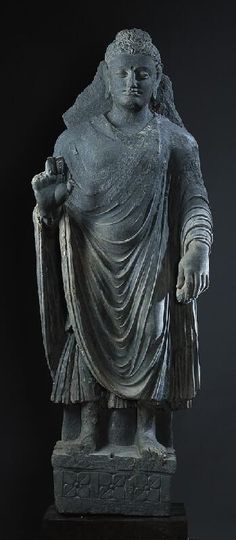 a statue of a man holding a bird in one hand and wearing a robe on the other