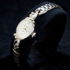 "Join our mailing list and receive 10% off your order: https://bit.ly/3puxhHb 1972 Bulova ladies \"Diamond Goddess F\" (case style 3551), 23-jewel watch in near mint condition. Dainty 10k rolled gold plate 70s timepiece with eight (8) Diamonds. 1.3mm/.01ct (.08tcw) accents. Oval case is polished finish with the Spray lugs in both polished and Florentine finish and an internally faceted crystal. Formal, luxury heirloom jewelry you can wear everyday. Great gift for a truly elegant woman. The Bulov Cocktail Watch, Heirloom Jewelry, Vintage Timepiece, Heirlooms Jewelry, Crystal Crown, Mailing List, Faceted Crystal, Silver Diamonds, Buy Vintage