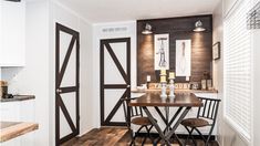 a kitchen table and chairs in front of an open door that leads to another room