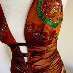 a woman's brown dress with green and gold beads