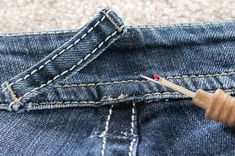 a wooden toothbrush sticking out of the back pocket of a pair of blue jeans