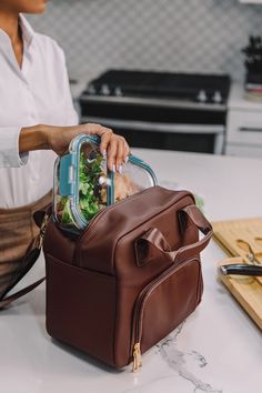 "The Tamarind lunch tote is made with vegan leather and is fashionable enough to carry your lunch in a way that matches your personal style. This sleek red interior redefines the way you bring your lunch to work. Each tote is hand-sewn and allows you to carry both hot and cold items in the insulated compartments. Next, the handle for the lunch bag is durable and is more than capable of holding a full day's worth of meals. Better yet, you can pair the T|W tote with your favorite suit. Lastly, eac Luxury Lunch Bags, Luxury Lunch, Leather Lunch Bag, Brown Luxury, Insulated Lunch Tote, Best Lunch Bags, Vegan Leather Tote, Insulated Bags, Insulated Lunch Box