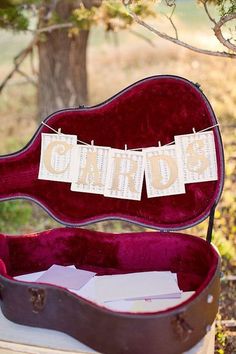 an old guitar case is sitting on a table with some paper hanging from the strings