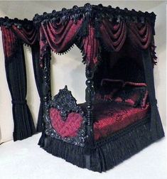 an elaborately decorated bed with red and black drapes