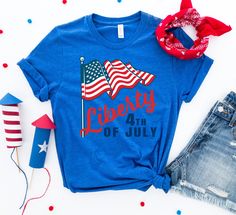 Celebrate our favorite American patriotic holiday with the Liberty 4th of July T-shirt! Featuring a traditional red, white, and blue design, this graphic tee is the perfect wardrobe piece for picnics, barbecues, fireworks, beach days, lake afternoons, amusement parks, patriotic events, and road trips! Pair with shorts or jeans, or layer with a kimono, cardigan, or jacket for an elevated style. Available in sizes S -3X in a variety of colors. Note: This product is an Embark Select item. Embark gi American Flag T-shirt For 4th Of July, Memorial Day Blue T-shirt With American Flag Print, Patriotic American Flag Print T-shirt For Summer, Summer Americana Pre-shrunk T-shirt, Summer Americana Style Pre-shrunk T-shirt, Patriotic Beach Tops With Flag Print, American Style T-shirt Made In Usa For Summer, Americana Style Pre-shrunk Summer T-shirt, Patriotic Blue T-shirt With American Flag