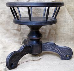 an old fashioned wooden chair with metal legs and foot rests on a fabric covered surface