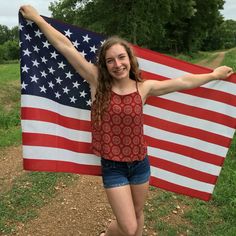 a girl holding an american flag in her hands