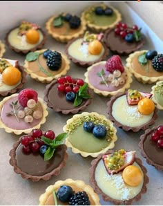 small desserts are arranged in the shape of pies with fruit toppings on them