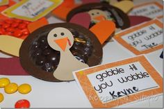 a turkey made out of candy sits on a table next to cards and candies that say gobble if you wobble