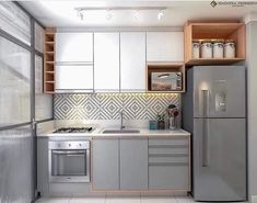 a small kitchen with stainless steel appliances and white tile flooring on the walls, along with open shelving