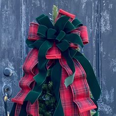 a red and green christmas wreath hanging on a door