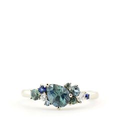 three stone ring with blue and white stones on the sides, set in 18k white gold