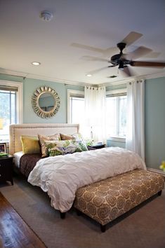 a bedroom with a bed, dresser and ceiling fan