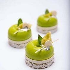 four green desserts with leaves and bows on them