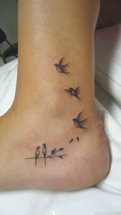 a small foot tattoo with birds on it