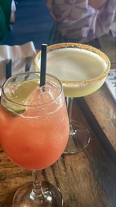 two cocktails sitting on top of a wooden table