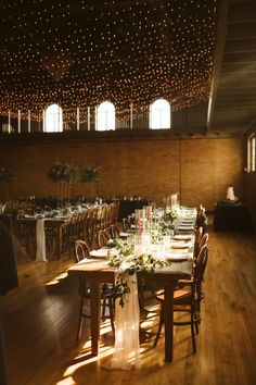 a long table with white flowers and greenery is set up for a wedding reception