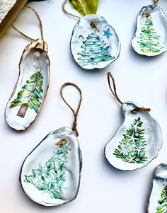 glass ornaments with christmas trees painted on them