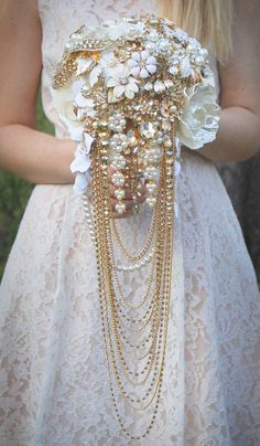 a woman in a white dress holding a bouquet with flowers and chains attached to it