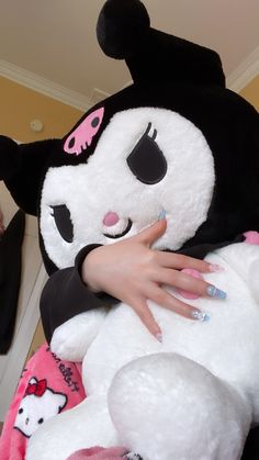 a woman holding a large stuffed animal in her arms with both hands on it's chest