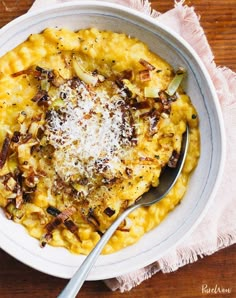 a white bowl filled with macaroni and cheese on top of a wooden table