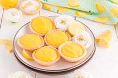 lemon tarts on a plate with flowers and napkins