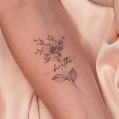 a woman's arm with flowers on it and the words be brave written in cursive writing