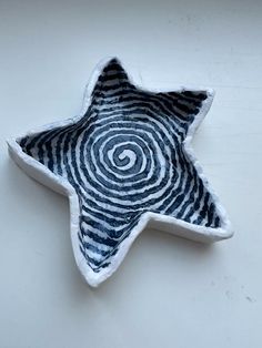 a star shaped dish with black and white designs on it