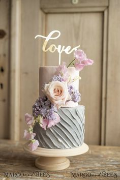 a wedding cake decorated with flowers and the word love