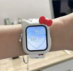 a person wearing a hello kitty watch on their arm with a chain around her wrist