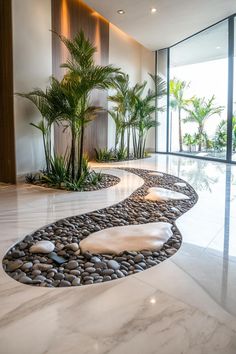 a large room with some plants and rocks on the floor