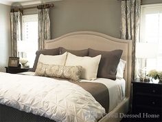 a bed with white and brown pillows in a bedroom