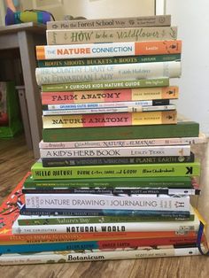 a stack of children's books sitting on top of a wooden floor in front of a white wall