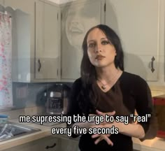 a woman standing in a kitchen with her arms crossed