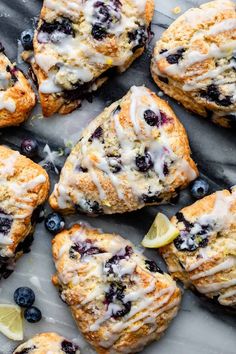 lemon blueberry scones with icing and fresh blueberries on a marble surface