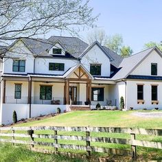 a large white house sitting on top of a lush green field