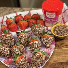 some strawberries are sitting on a plate next to other foods