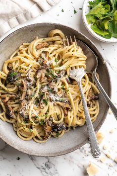 pasta with mushrooms and parmesan cheese in a bowl on a marble countertop