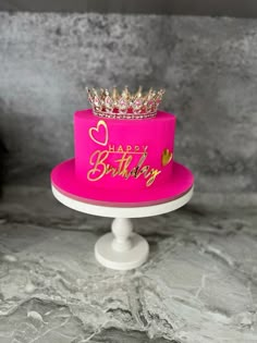 a pink birthday cake with a crown on top