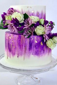 a white and purple cake with flowers on top