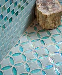 a tree stump sitting on top of a blue tiled floor next to a bath tub